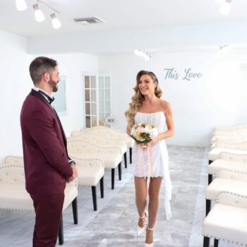 Bride walking toward groom for first look inside Las Vegas wedding chapel